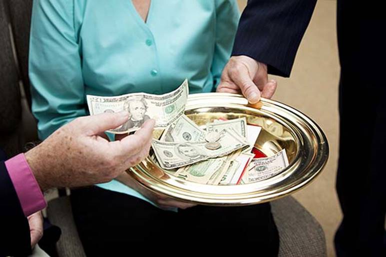 This offering plate with voluntary contributions in it illustrates how members of the church of Christ finance spiritual works of evangelism and benevolence, not by means of a tithe, which was abolished on the cross, but by generous giving according as each one has prospered, this being the New Testament rule.