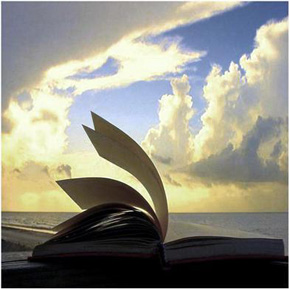 Una Biblia abierta contra un bello trasfondo de cielos, nubes y mar.