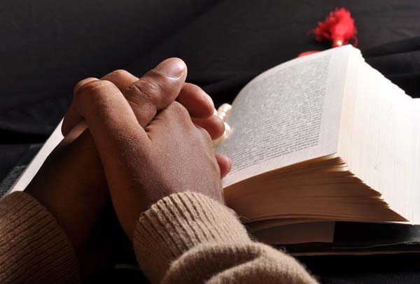 Esta fotografía de manos encima de una Biblia abierta ilustra el tema De pastor pentecostal y Ministro competente del Nuevo Pacto, en editoriallapaz.
