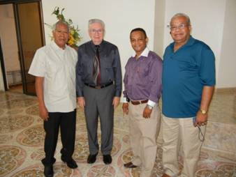 Miguel Molina, left, standing with Dewayne Shappley, Bro. Chico and Bro. Orlando Rivera, at the front of the Bayamón, Puerto Rico church of Christ auditorium. 