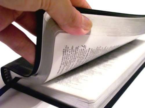 Esta fotografía de una mano que abre una Biblia ilustra el intercambio ¿Meda Biblia, medio Antiguo Testamento o toda la doctrina de Cristo?, en editoriallapaz.org.