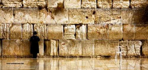 Un varón judío solitario se para ante la Muralla Occidental, o Muralla de los Llantos, bellamente iluminada en tonos de oro y marón, fotografía que ilustra el tema Los judíos de hoy día: ¿perdiéndoselo?