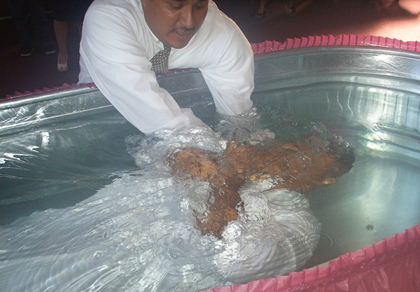 En esta fotografía, se realiza el bautismo de un adulto por inmersión, ilustración para el tema ¿Es válido ante Dios tu bautismo?