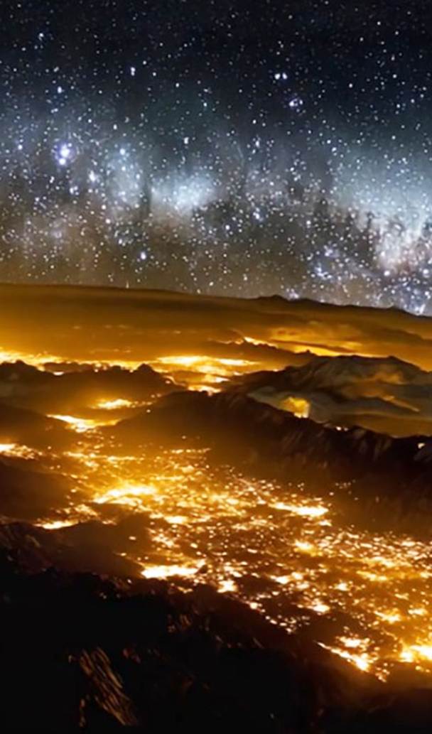 Una intensa lluvia de meteoros se desplaza, durante la noche, sobre ciudades y pueblos situados en valles entre montañas.