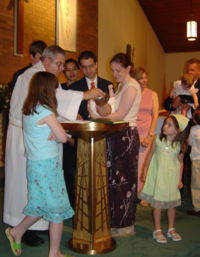 Fotografía del bautismo por aspersión de un niño en una Iglesia Católica Romana, ilustración para el tema ¿Por qué es usted católico romano?