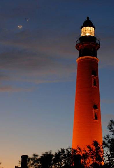 A red and white lighthouse  Description automatically generated with medium confidence