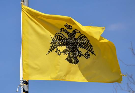Una imagen de la bandera del Imperio Romano Oriental con su águila de doble cabeza sobre un trasfondo amarillo.