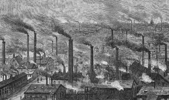 Fotografía en blanco y negro de gran número de fábricas textiles en Gran Bretaña en el siglo XVIII, con chimeneas muy altas de las que emanan una cantidad enorme de humo y otros contaminantes.