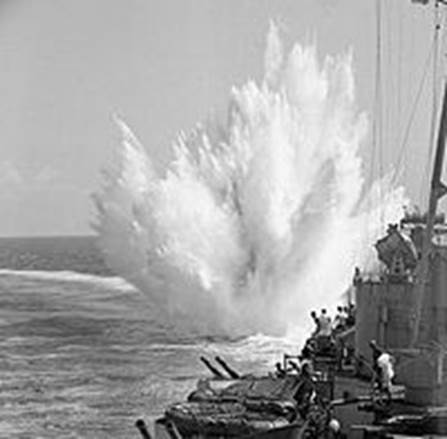 Trompeta 2 de Apocalipsis. Impactada la vida marina. Buque de guerra lanza cargas de profundidad durante la II Guera Mundial.