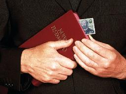 Un predicador sostiene un Nuevo Testamento en sus manos, con dinero intercalada en las hojas, lo cual indica que su prioridad es el "evangelio de la prosperidad", y no la pura verdad divina de la Palabra inspirada.