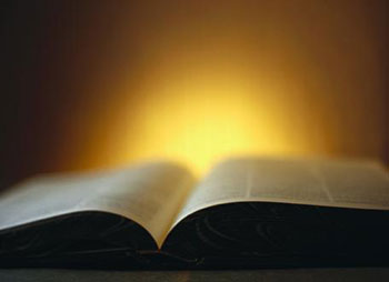 Una Biblia abierta frente a un resplandor que evoca la poderosa luz de Dios ilustra el tema Los dones sobrenaturales cesan conforme a las profecías y explicaciones del Espíritu Santo, imagen-diapositiva para el tema.