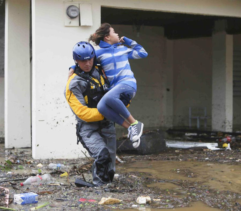 Barrio San Isidro, Canóvanas, Puerto Rico. Una jovencita rescatada de una casa inundada. Barrio San Isidro, Canóvanas, Puerto Rico. A young girl is rescued from a flooded home.
