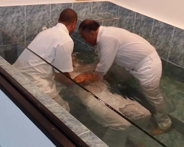 At the Wednesday night service, Sept. 10, 2014, Luis Samuel Luciano, about 45 years old, is baptized by Jorge Ginés López and Rafael Torres, two men who preach, teach and lead singing in the Bayamon church. 