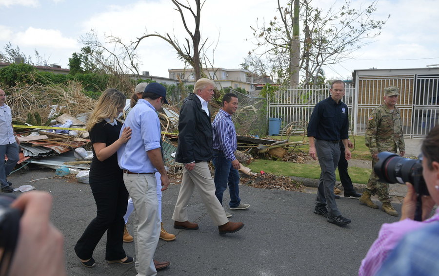 El presidente Donald Trump visita con algunos ciudadanos en Guaynabo, Puerto Rico, el 3 de octubre de 2017. Pasando por una calle con escombros amontonados por un lado, pregunta a algunos dueños de residencias: “¿Qué experimentaron durante el huracán? ¿Vibraron las casas de concreto a ser impactadas por los vientos tan fuertes? ¿Cómo se comparan las casas de madera con las de concreto en tales circunstancias?” Etcétera. 