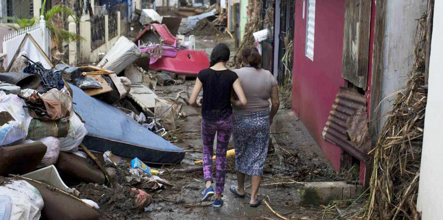 Ciudad sureña de Puerto Rico, entre Ponce y Mayagüez. Gran cantidad de muebles, enseres, etcétera, dañados a consecuencia del paso del huracán María, amontonados en una acera por la cual andan con dificultad dos damas, quizás madre e hija. Aquí, existe una congregación de la Iglesia de Cristo.