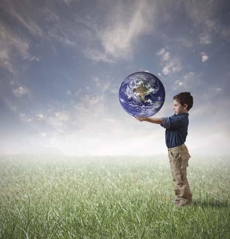 Imagen de un niño que sostiene en sus manos extendidas un globo del planeta Tierra.