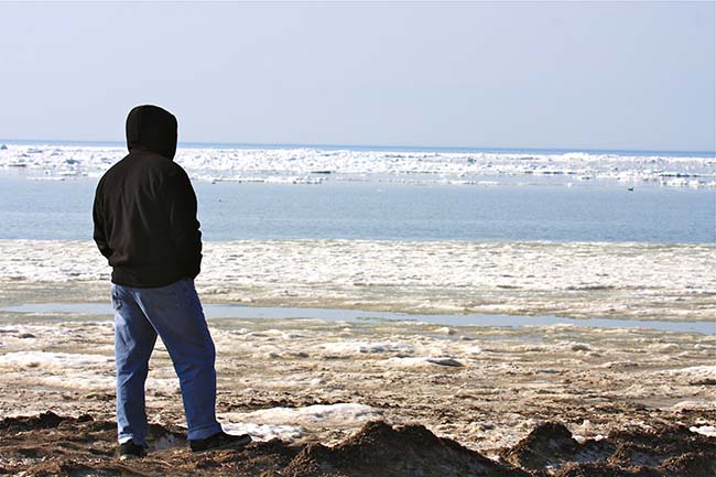 Esta fotografía de un varón solitario parado en la playa frente al mar, como meditabundo, ilustra el tema Joven cristiano pide consejos para vencer la tentación de ver pornografía, en editoriallapaz.org.