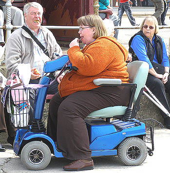 Una mujer tan obesa que tiene que valerse de un carrito especial para trasladarse ilustra la adiccion a comida, la que es la nueva droga de multitudes.