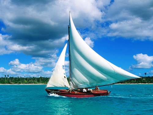 Este barco con dos velas blancas que se desliza por aguas cerca de la costa de la República Dominicana ilustra el tema El deber del hombre, en editoriallapaz.
