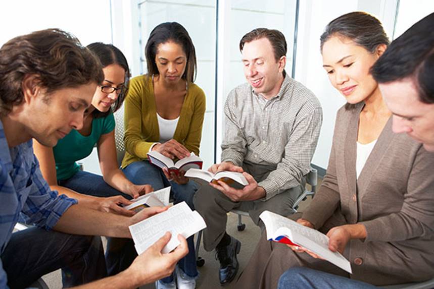 Fotografía de seis adultos jóvenes de distintas razas ocupados en el estudio de la Biblia.